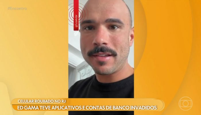 Celular roubado. Ed Gama aparece em vídeo exibido no programa Encontro, da TV Globo, relatando o roubo do celular e a invasão de aplicativos bancários. Na tela, uma legenda informa que o humorista teve contas e aplicativos de banco invadidos após o crime.